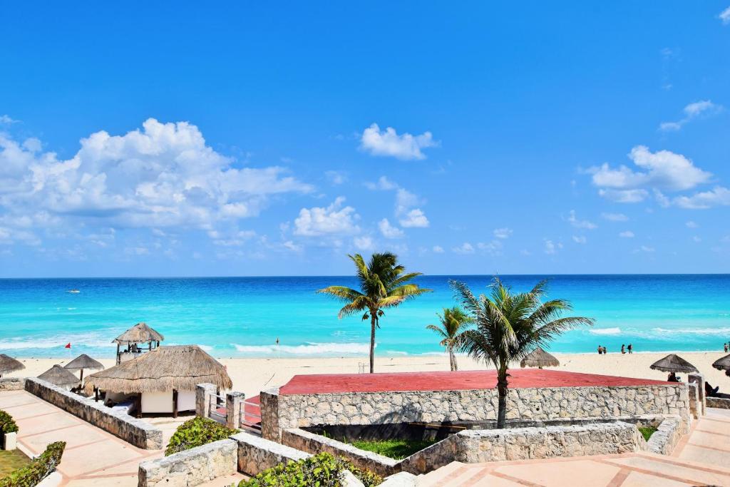 a view of a beach with palm trees and the ocean at Solymar Condo Beach Resort by Casago in Cancún