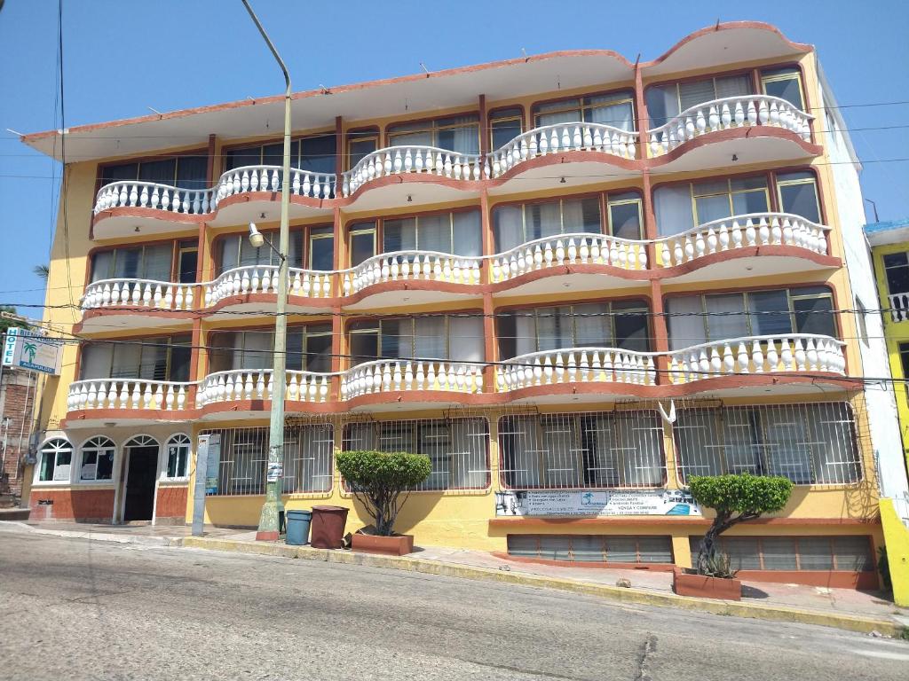 an orange building with white balconies on a street at Hotel Olimar in Acapulco