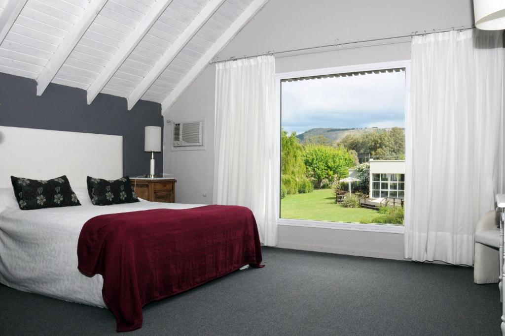 a bedroom with a bed and a large window at Brisas Serranas in Tandil