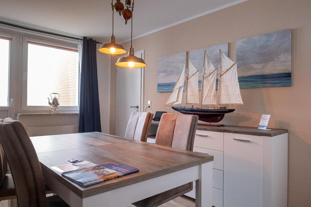 a dining room with a table with a model ship on the wall at Witte Kliff Helgoland in Helgoland