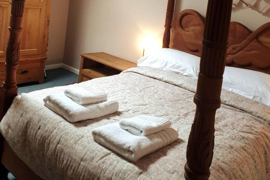 a bedroom with a bed with three towels on it at Otters' Raft in Weston-super-Mare