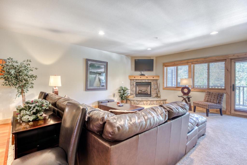 a leather couch in a living room with a fireplace at Grand Lodge South #102 in Government Camp