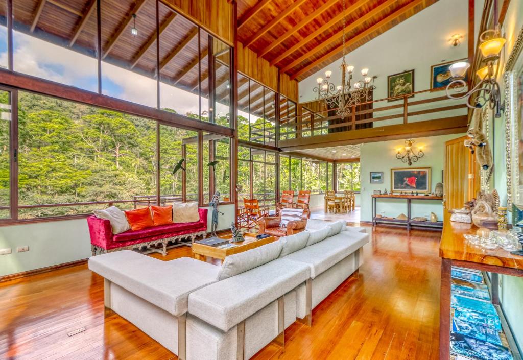 an open living room with a large couch and chairs at Casa Cielo in Fortuna