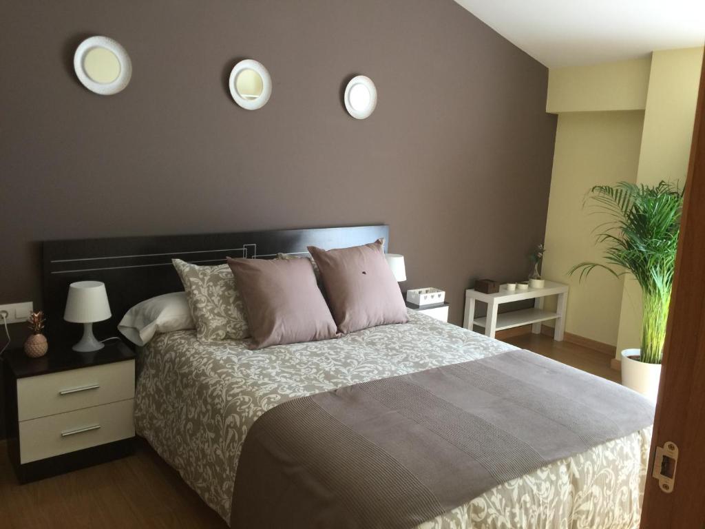 1 dormitorio con 1 cama y 2 espejos en la pared en Apartamentos Turísticos Clavero 2, en Plasencia