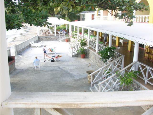 a person sitting in a chair outside of a building at Paradise Beach Hotel in Kingstown