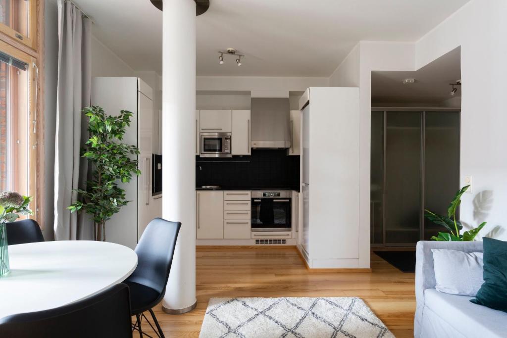 a kitchen and living room with a table and chairs at 2ndhomes Deluxe 1BR Kamppi Center Apartment with Sauna and Terrace in Helsinki