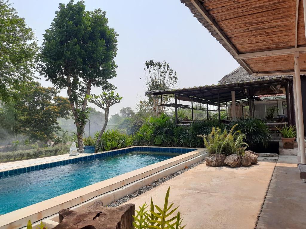 a swimming pool in front of a house at Pingplalee Resort in Sai Yok