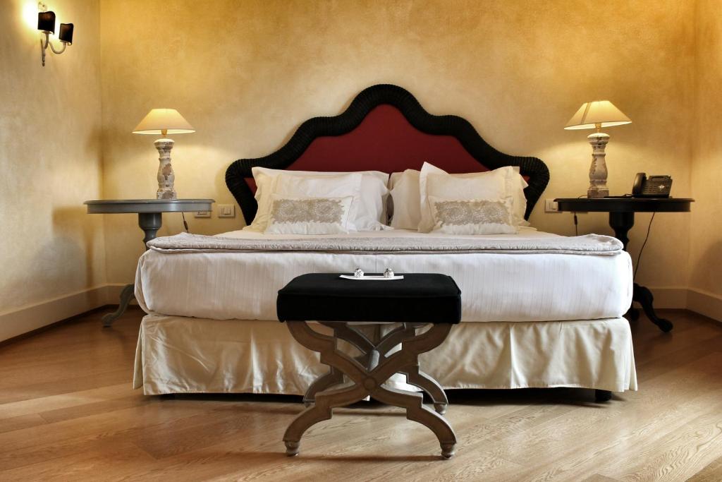 a bedroom with a large bed with two tables at Siri Hotel in Fano
