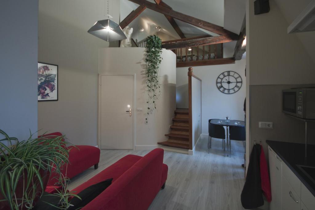 een woonkamer met een rode bank en een tafel bij Appartement Stokroos in Lottum
