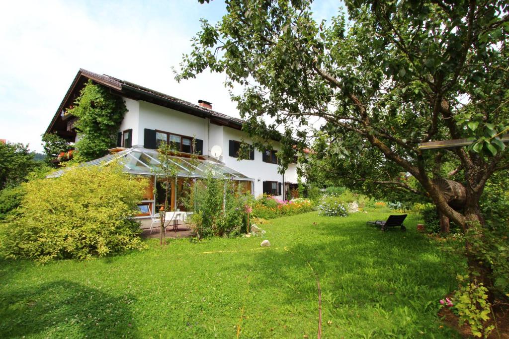 una casa con un patio verde delante de ella en Ferienwohnung Maag, en Lechbruck