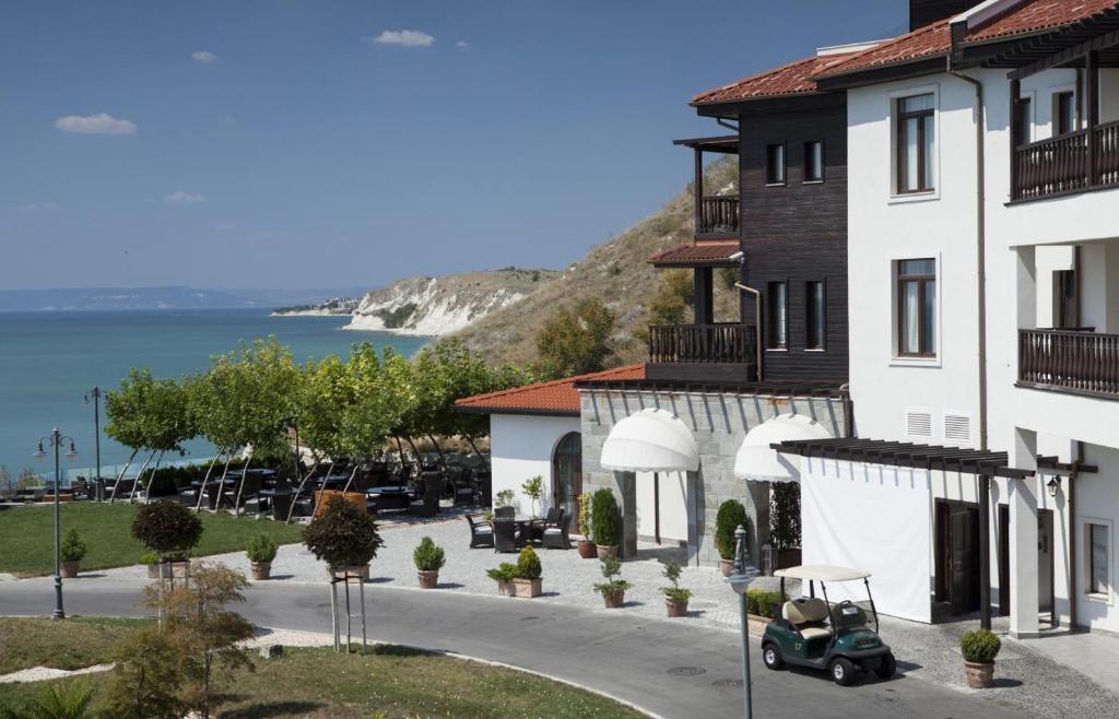 a building with a car parked next to a street at Thracian Cliffs Owners Apartments in Kavarna