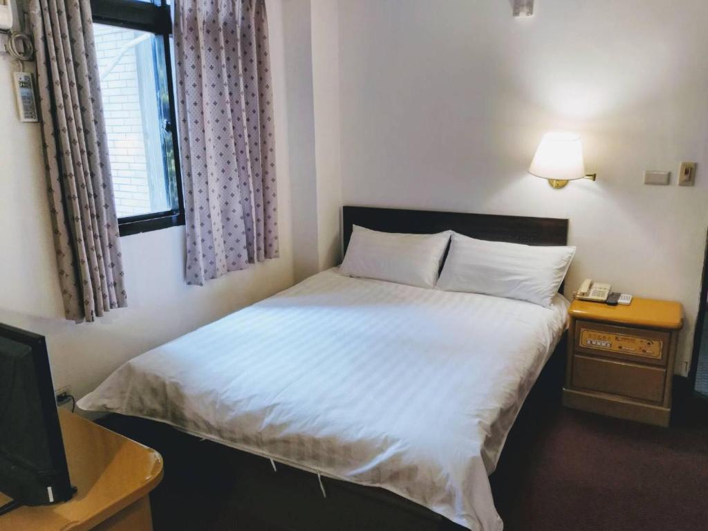 Un pat sau paturi într-o cameră la 金麗麗大飯店