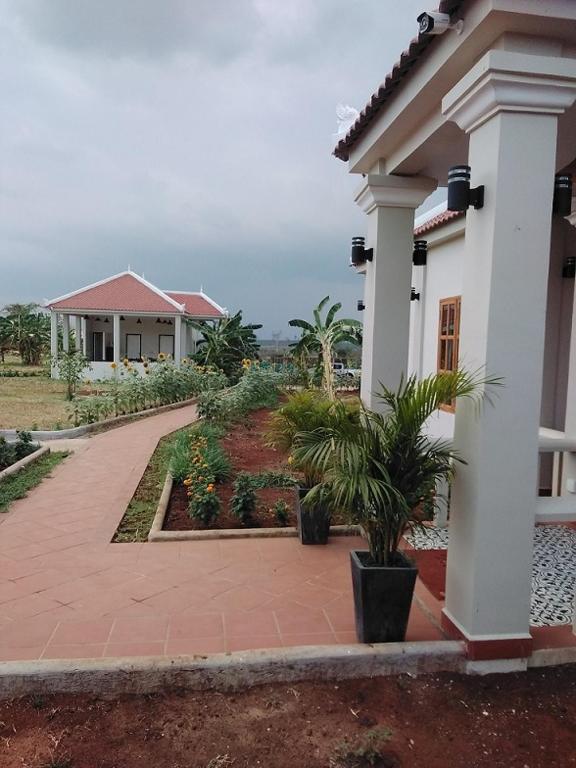 a house with a walkway in front of a building at Koh Ker Hotel and Restaurant in Phumĭ Mréch