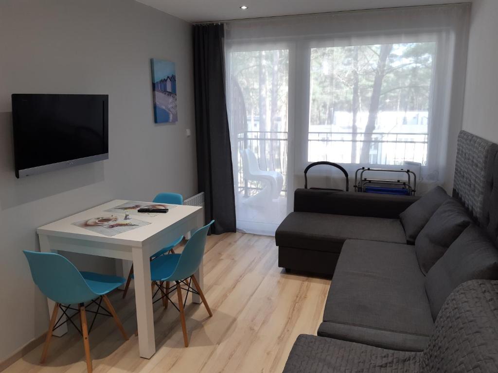 uma sala de estar com um sofá e uma mesa em Blue Mare Perfect em Łukęcin