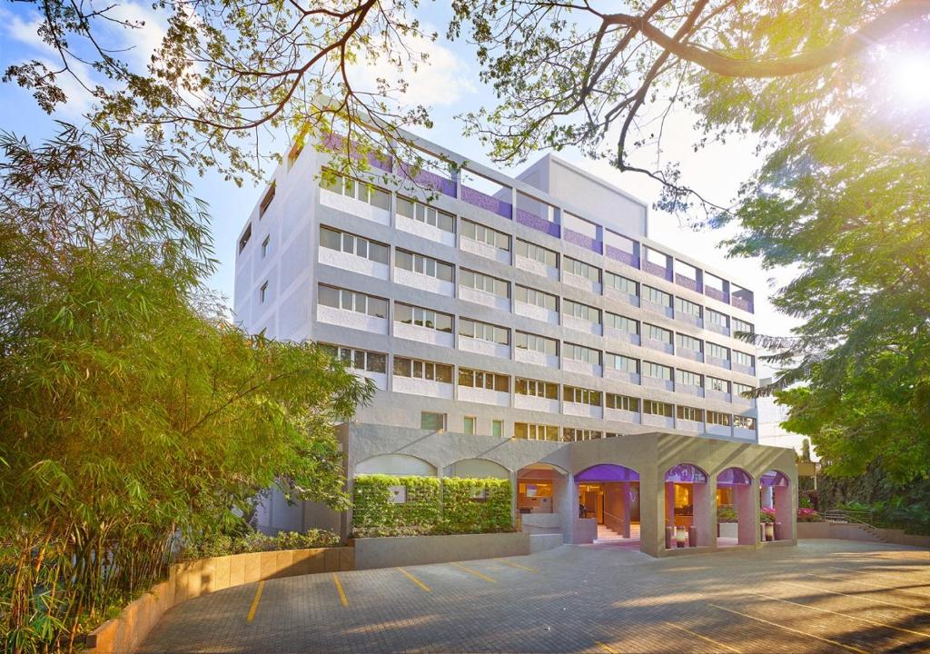 a large white building with a parking lot in front of it at Vivanta Bengaluru Residency Road in Bangalore