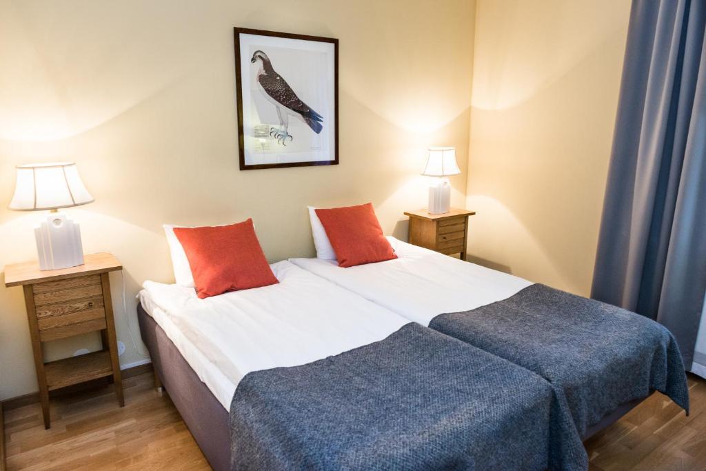 1 dormitorio con 1 cama con 2 mesitas de noche y 2 lámparas en Nordens Ark Hotell en Stranderäng