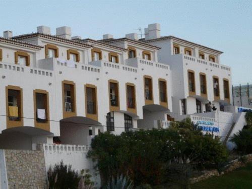 un gran edificio blanco con muchas ventanas en Apartamentos Os Descobrimentos en Burgau