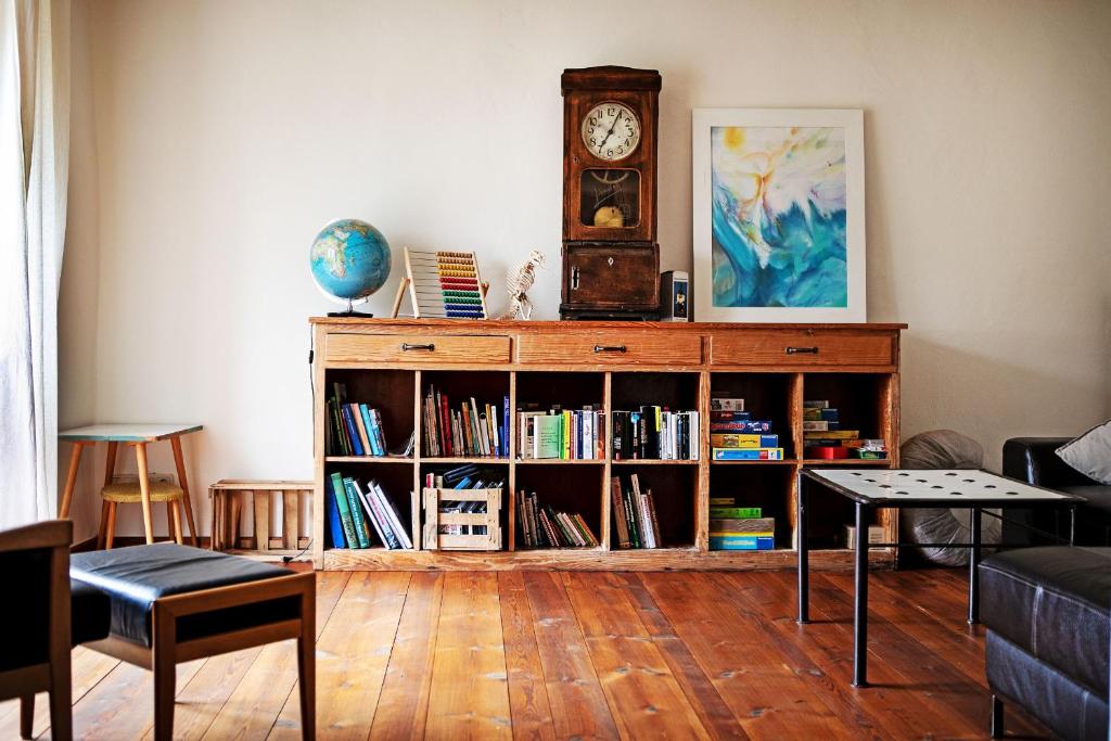 a living room with a book shelf with a clock at Ferienhaus auf Gut Weimarschmieden in Fladungen