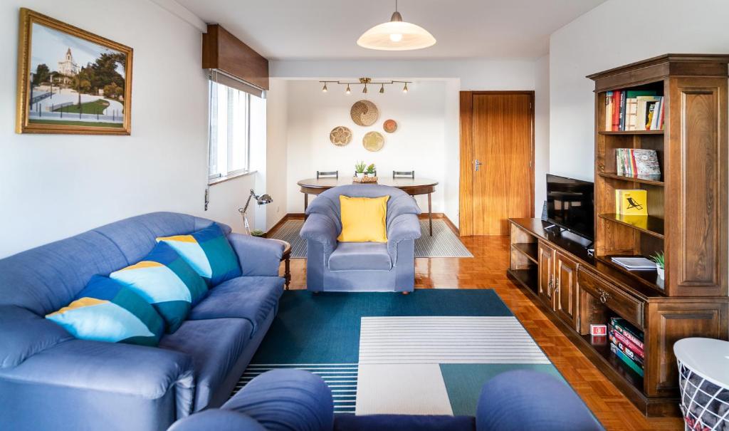 a living room with a blue couch and a table at Cozy 3 Room Apartment in Penafiel Centre in Penafiel