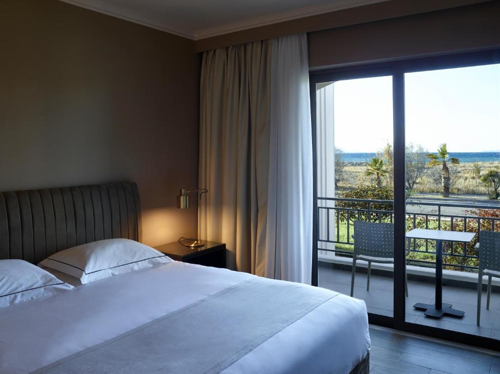 A bed or beds in a room at Pelagos Suites Hotel & Spa