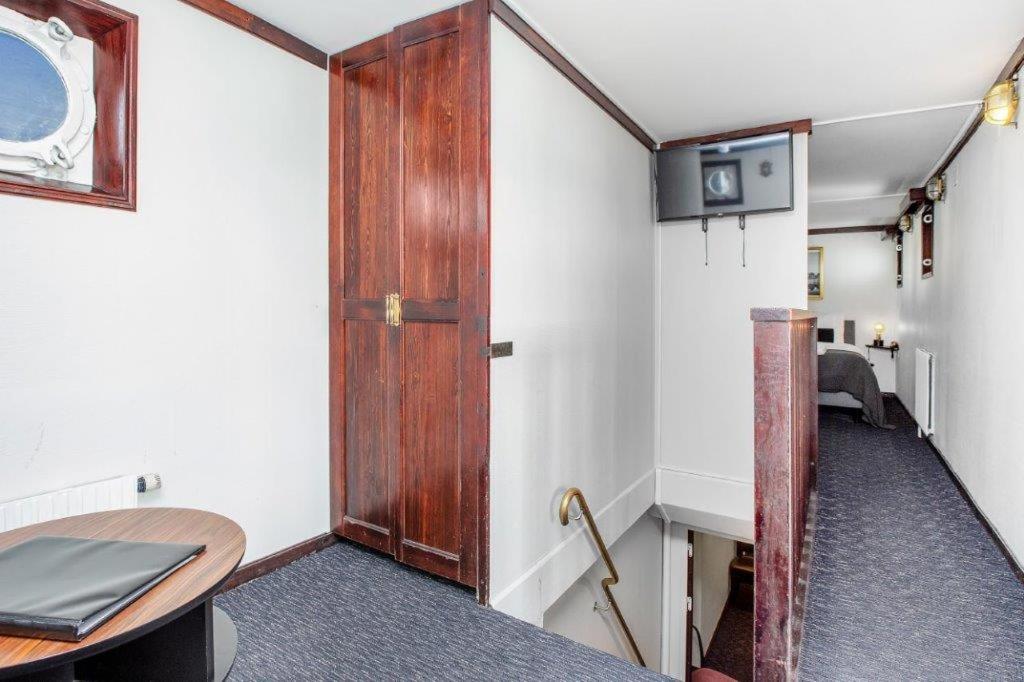 a room with a wooden door and a table at Mälardrottningen Yacht Hotel in Stockholm