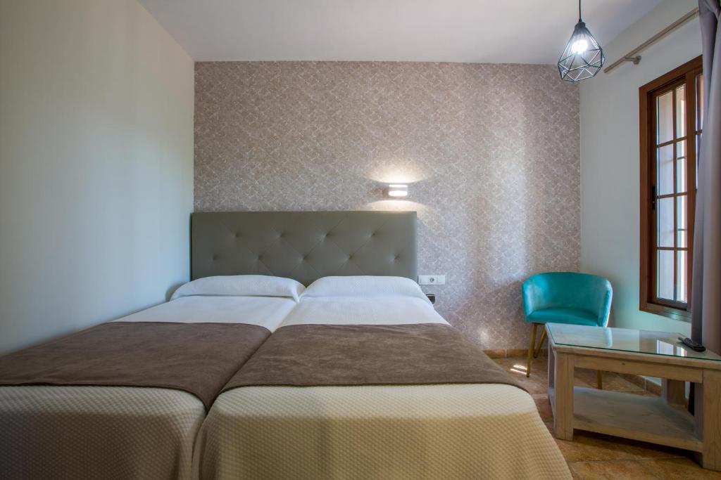 sypialnia z łóżkiem, stołem i krzesłem w obiekcie Hostal Don Joaquín Alora w mieście Alora