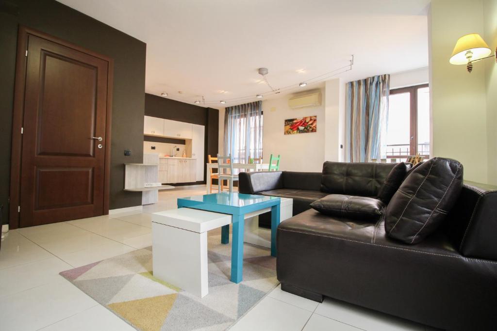 sala de estar con sofá negro y mesa en Trendy & Deluxe Apartment, en Plovdiv