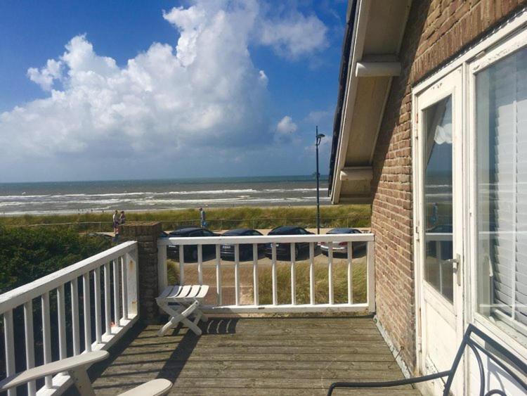 a porch with a bench and a view of the beach at Pacific, spectacular seaview in Bergen aan Zee