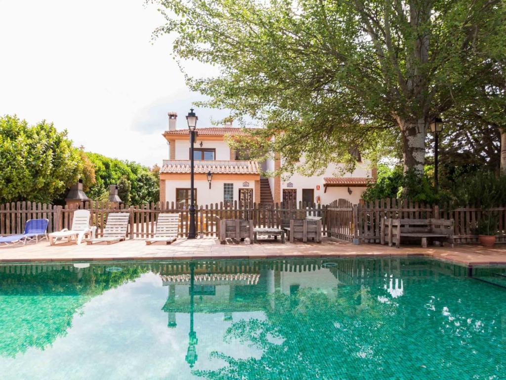 una piscina con sillas y una casa en el fondo en Camino de los molinos, en El Padul