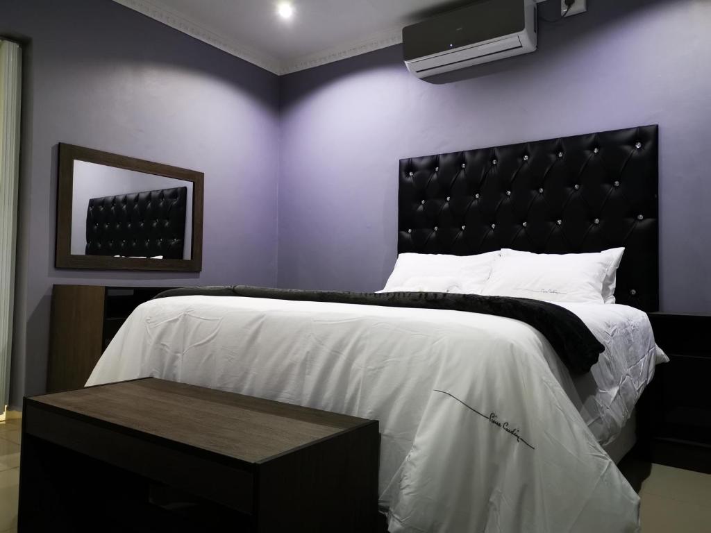 a bedroom with a large bed with a black headboard at Green Olive Residences in Bethlehem