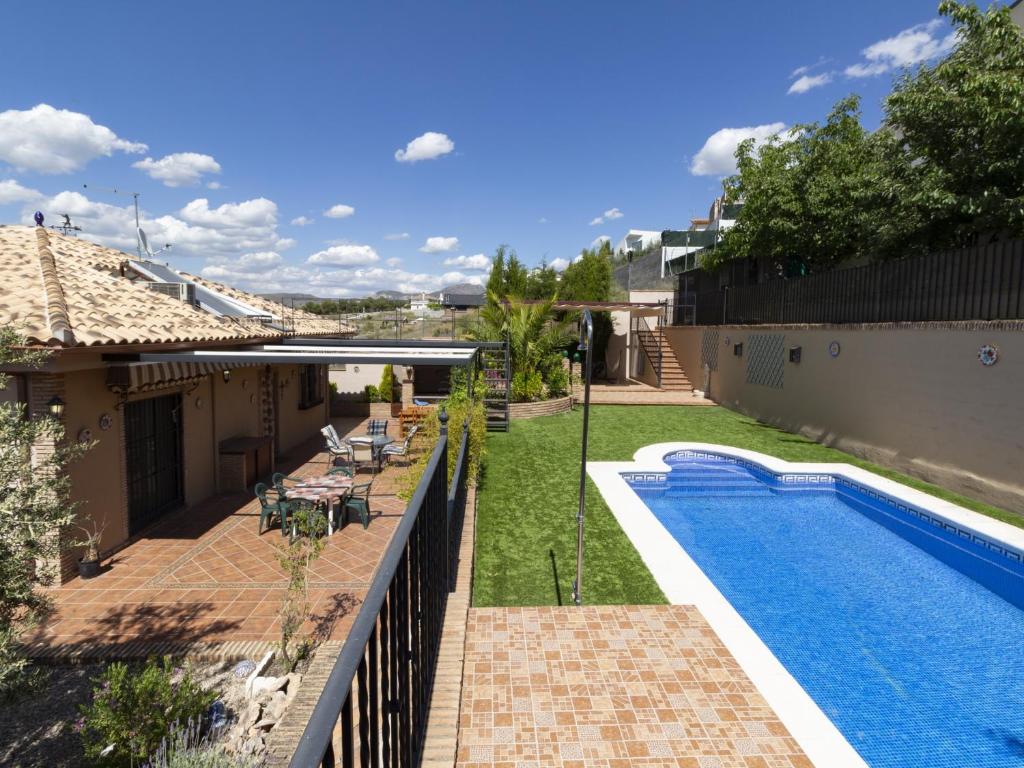 a backyard with a swimming pool next to a house at Casa jofrais in La Zubia