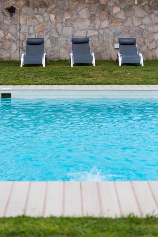two chairs sitting next to a swimming pool at Hotel Nómadas in Vejer de la Frontera