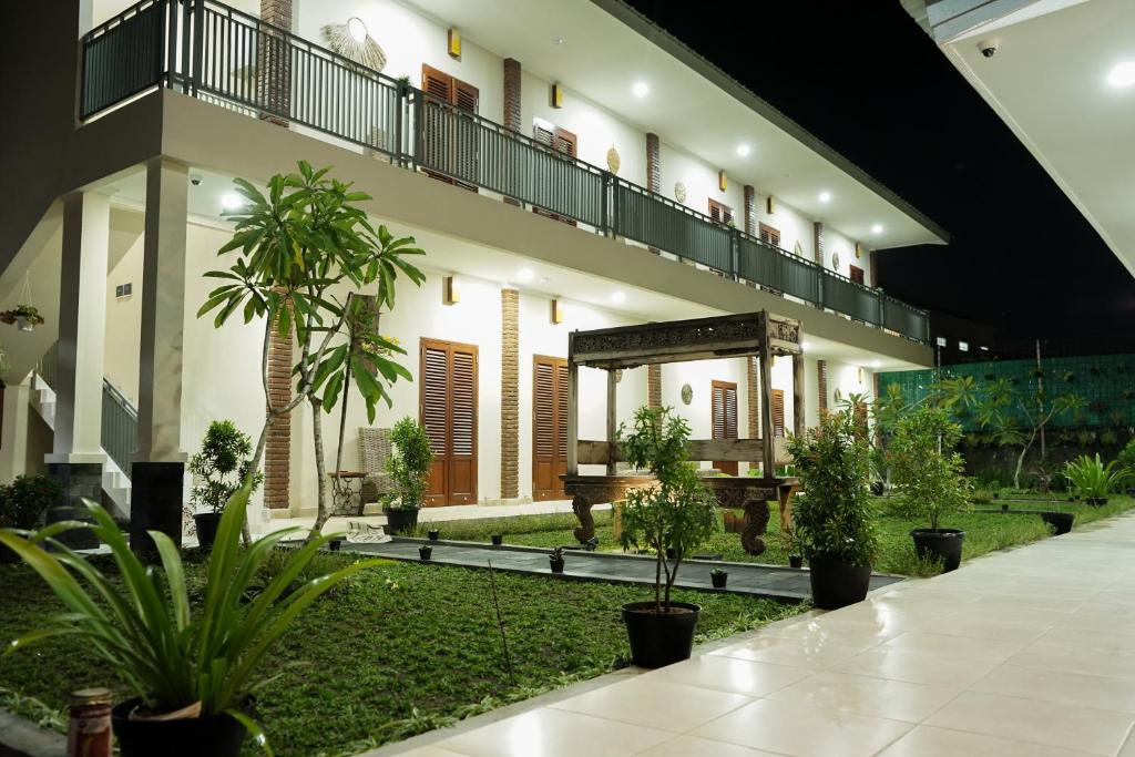een gebouw met een binnenplaats met bomen en planten bij Naima Jiwo in Yogyakarta