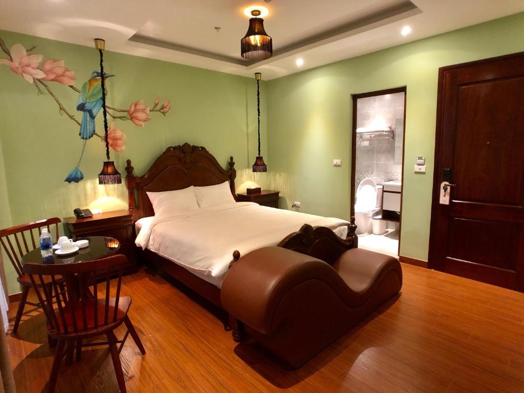 Un pat sau paturi într-o cameră la Le Grand Hanoi Hotel - The Oriental