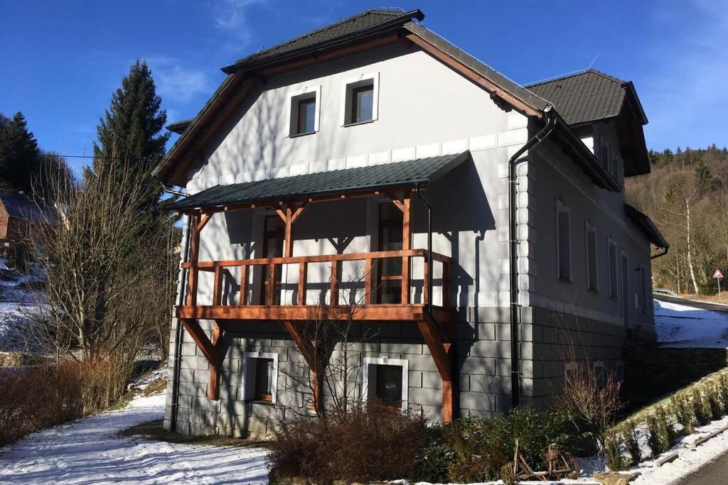 a house with a deck on the side of it at Villa Vykmanov in Měděnec