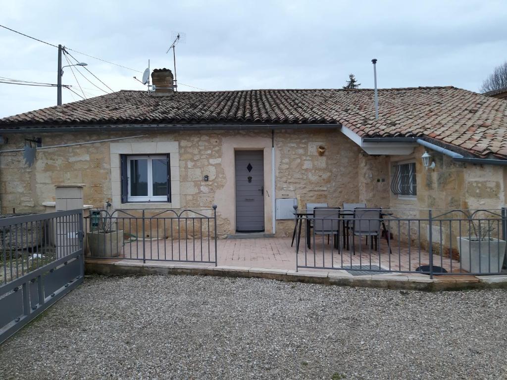 a stone house with a table and chairs in front of it at Gite Les Deux Meules in Sainte-Colombe