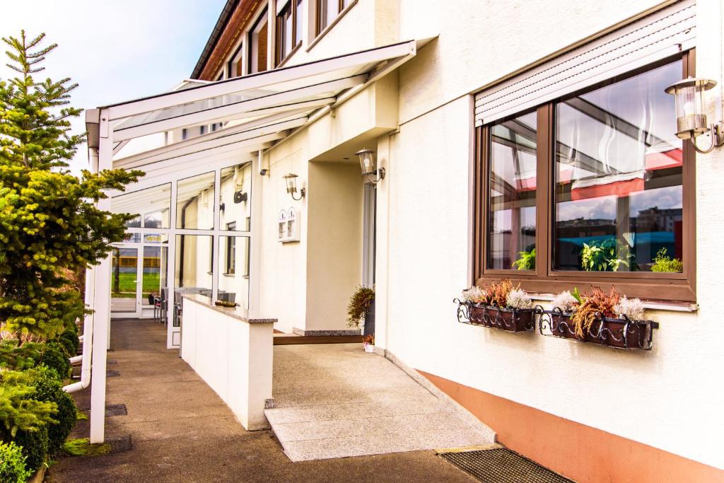 a white building with windows and potted plants at Hotel Bohn in Metzingen