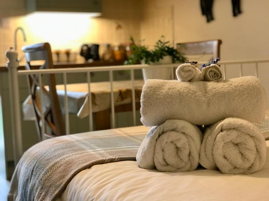 a pile of towels sitting on top of a bed at Brinsley Barn in Blagdon