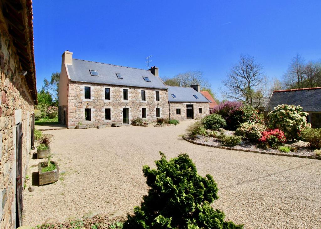 a large stone house with a large driveway at La Maison Kérès in Kermaria-Sulard