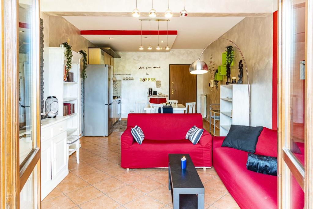 een woonkamer met een rode bank en een keuken bij Relax Apartment in Ladispoli