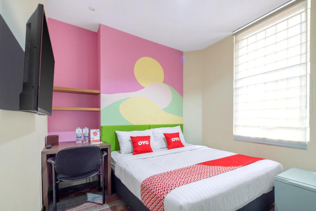 una camera con un letto con una parete colorata di Super OYO Capital O 1121 Orienchi 2 a Giacarta