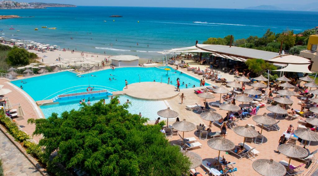 una vista aérea de una piscina con sombrillas y una playa en Almiros Apartments, en Agios Nikolaos