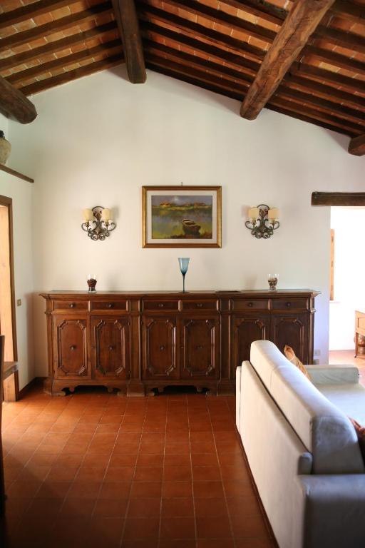 a living room with a couch and a painting on the wall at Villa Santa Maddalena in Cetona