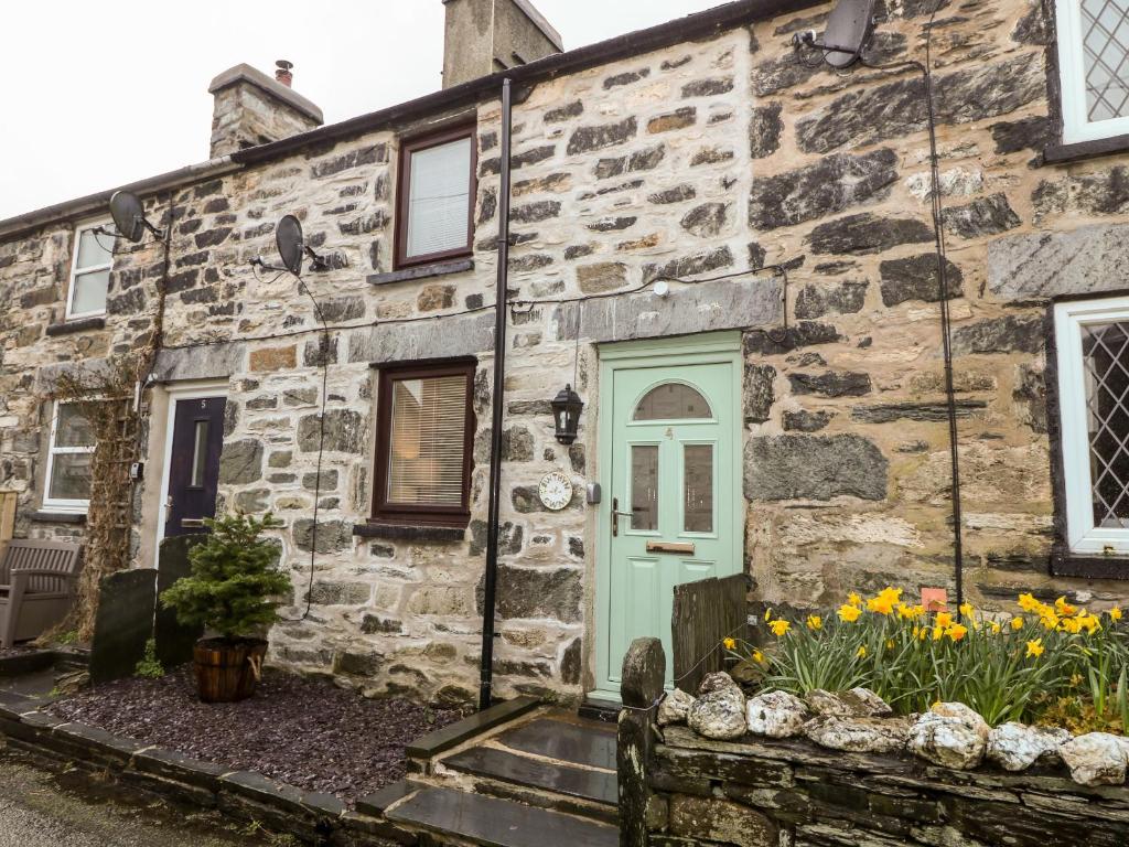 an old stone house with a green door at Bwthyn Y Cwm in Betws-y-coed