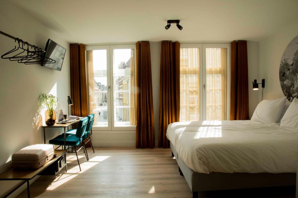 Schlafzimmer mit einem Bett, einem Schreibtisch und einem Fenster in der Unterkunft Hotel Haverkist in ’s-Hertogenbosch
