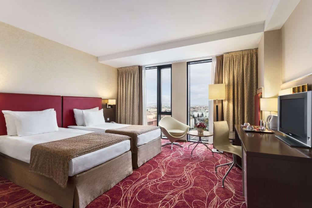 Postel nebo postele na pokoji v ubytování Ramada Sibiu Hotel