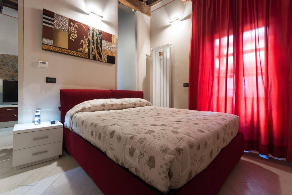 Schlafzimmer mit einem großen Bett und roten Vorhängen in der Unterkunft Perla al centro di Torino - next Mole in Turin
