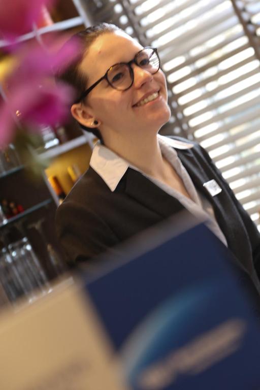 uma mulher de óculos sentada numa mesa em Best Western Plus Delmere Hotel em Londres