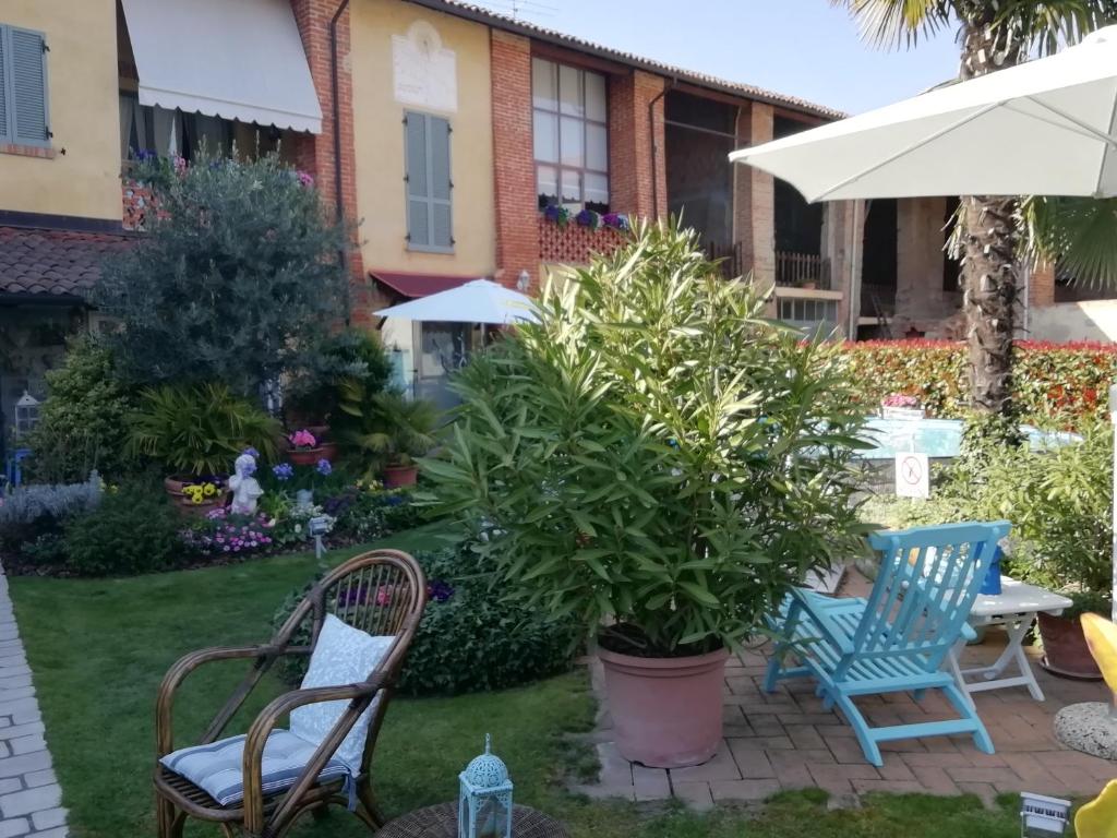 a patio with chairs and plants and an umbrella at B&B San Valerio in Occimiano