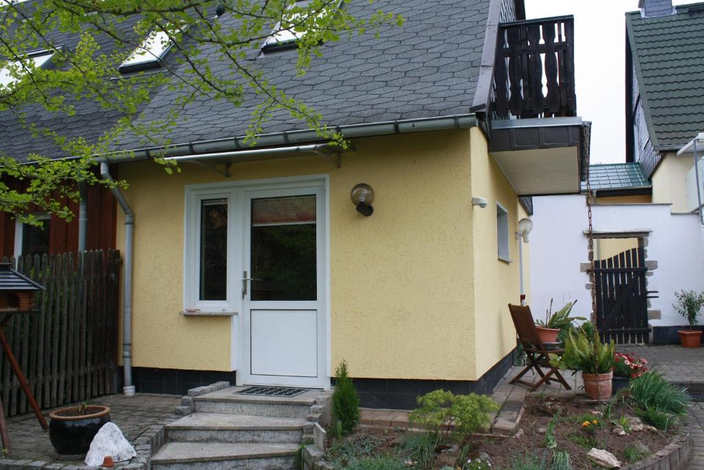 a yellow house with a white door at FEWO Wittig in Ilfeld